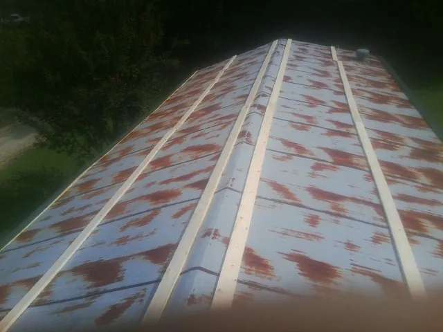Rusted metal roof panels with new wood purlins before replacement — Storm Damage Roof Repair in Schulenburg by Roofing Brothers