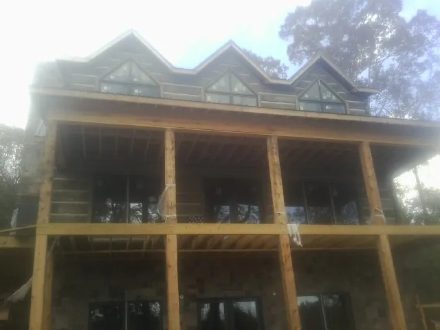 Dormers and porch framing on a large log home under construction — Roof Coating work by our crew in Schulenburg