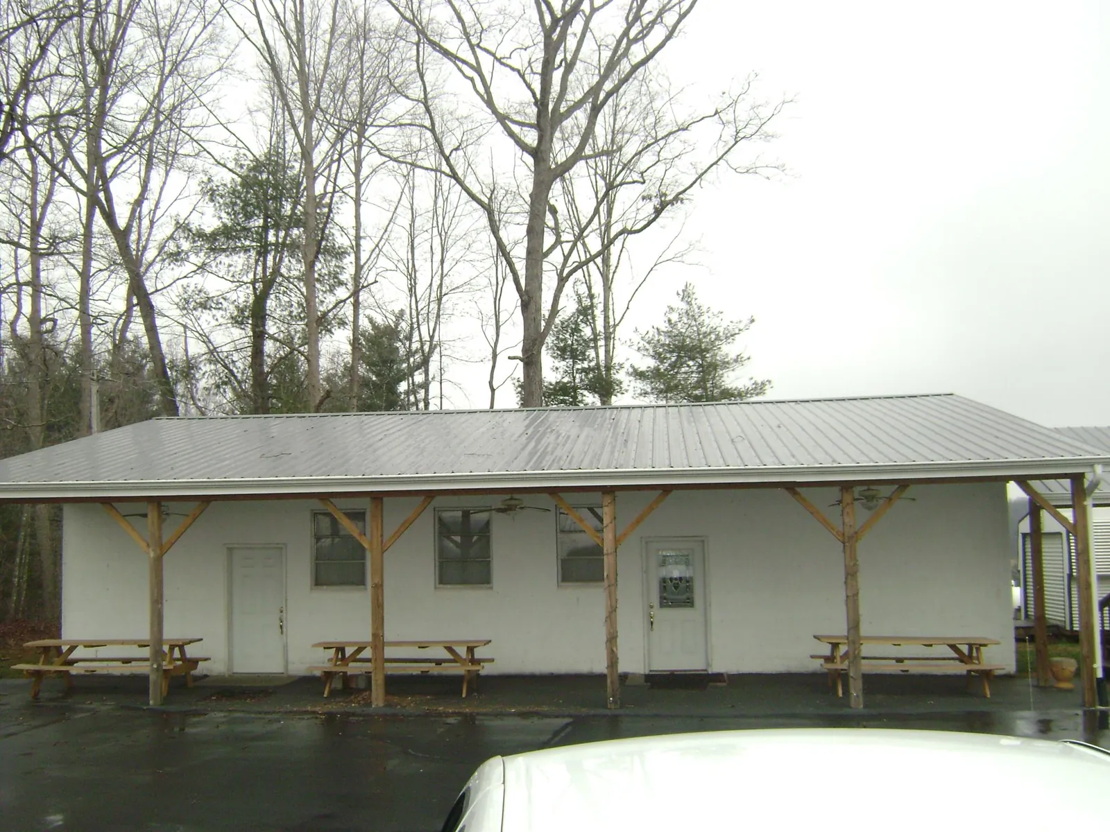 Gray metal roof over a block building with a timber post porch in Schulenburg